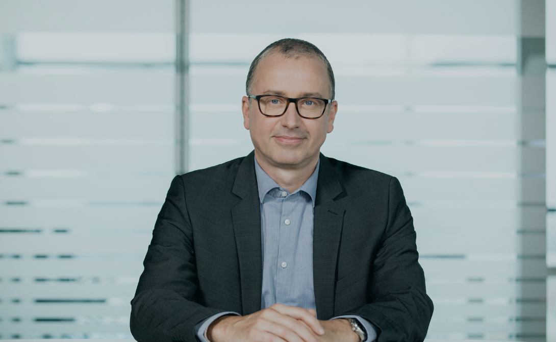 Portrait of a business executive seated at a desk – representing a conversation on IT industry trends, growth, and innovation in 2023.
