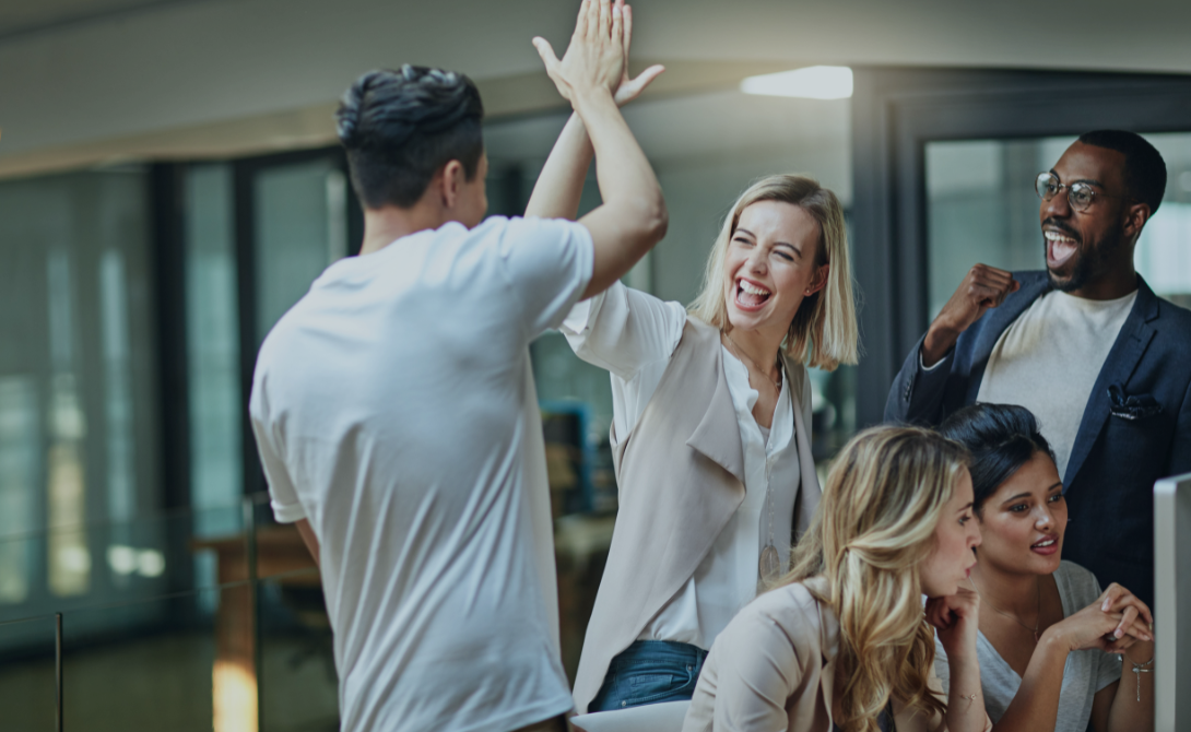 Cheerful business team celebrating success in a modern office – representing CONVOTIS’s recognition as a Top 25 IT services provider in Germany.