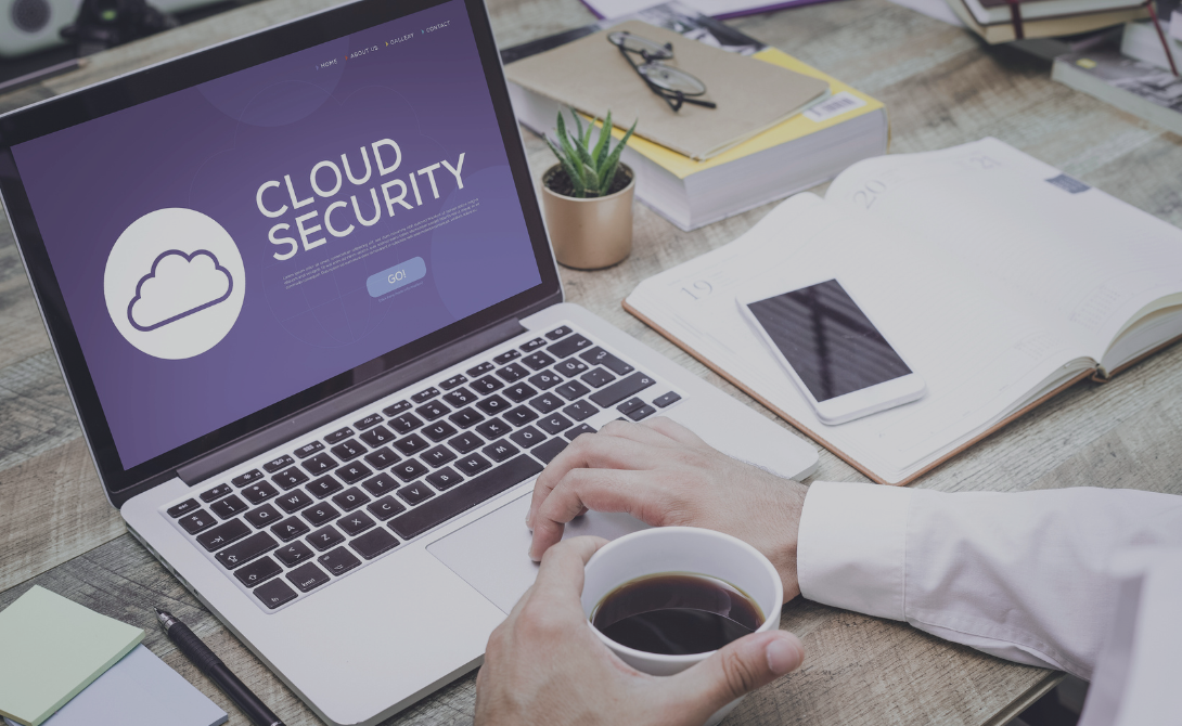 Close-up of a laptop screen showing “Cloud Security” with a coffee cup in hand – symbolizing secure cloud computing in a professional environment.